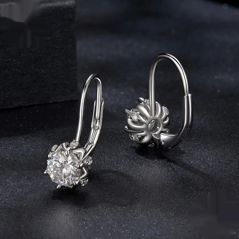 A pair of sterling silver flower bud design ear clips with white gold plating and moissanite stones.