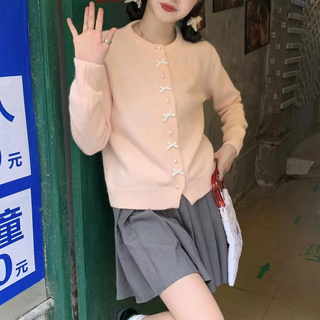 Women's solid colour cardigan sweater with bow and pearl button design in medium thickness fabric