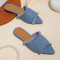 Solid colour denim women's slippers with a tassel detail, showing leather lining and PVC sole.