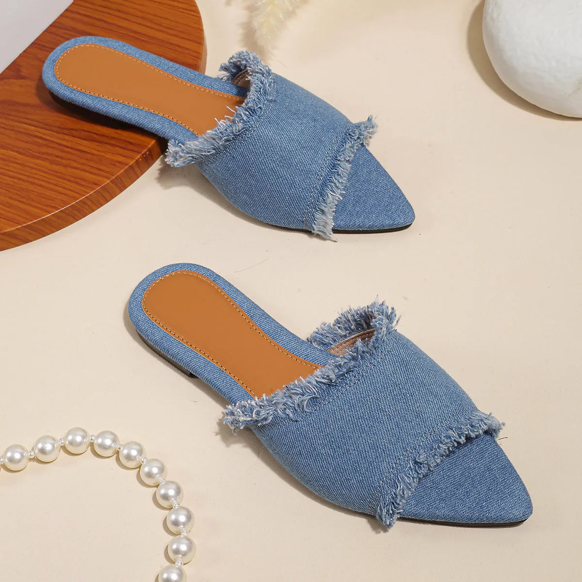 Solid colour denim women's slippers with a tassel detail, showing leather lining and PVC sole.