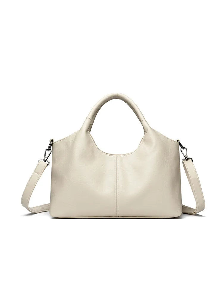 Women's genuine leather crossbody bag in beige colour showing soft construction and large capacity