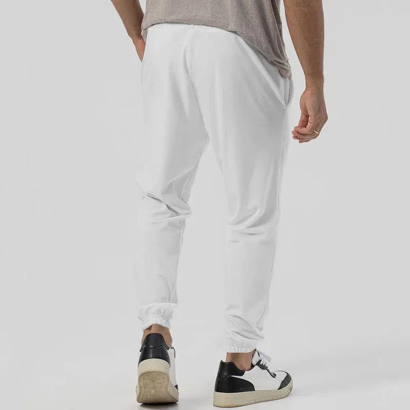 Men's grey loose tapered track sweatpants with elastic waist and straight leg design.