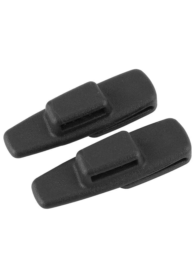 Two black ABS plastic car seat belt stopper clips on vehicle seat