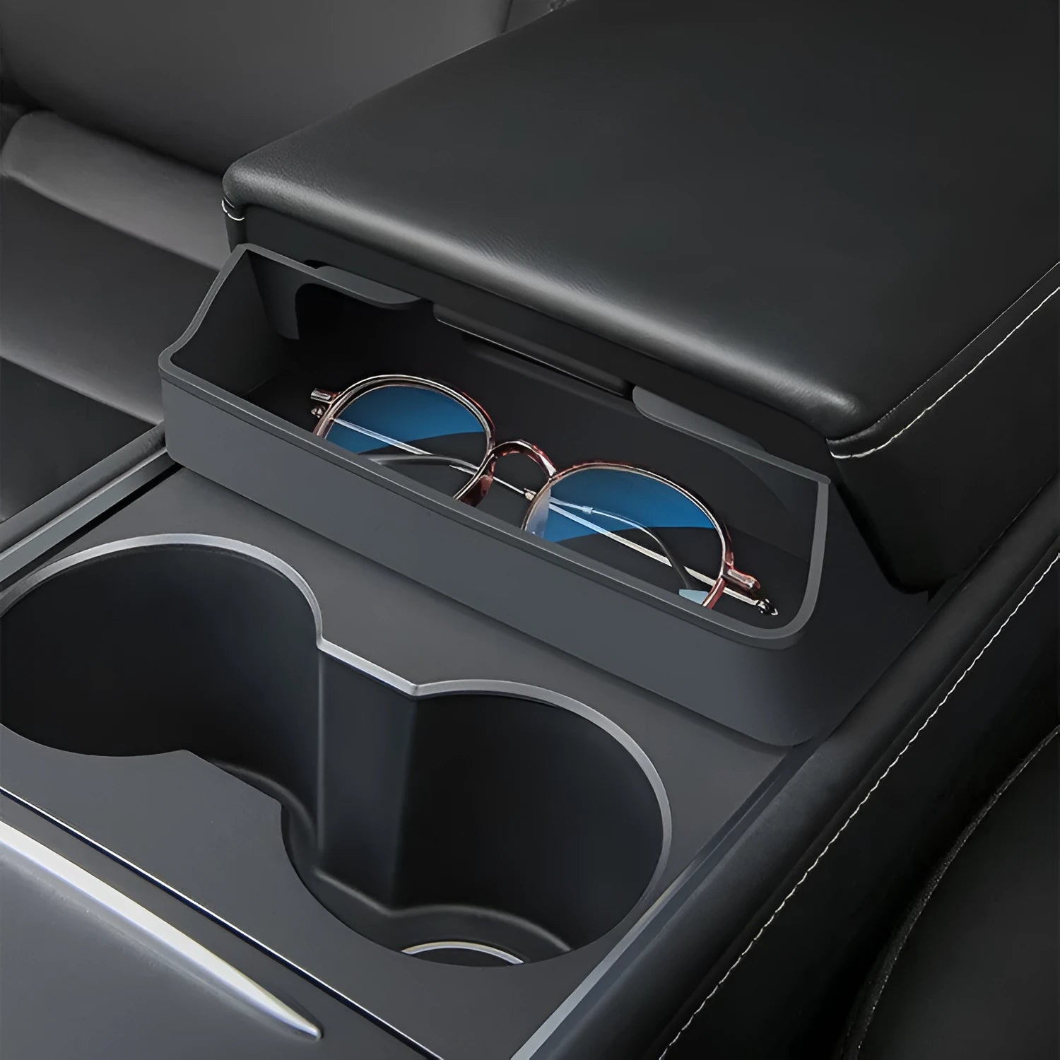 Black silicone glasses storage case installed in a Tesla Model 3 or Y centre console armrest.