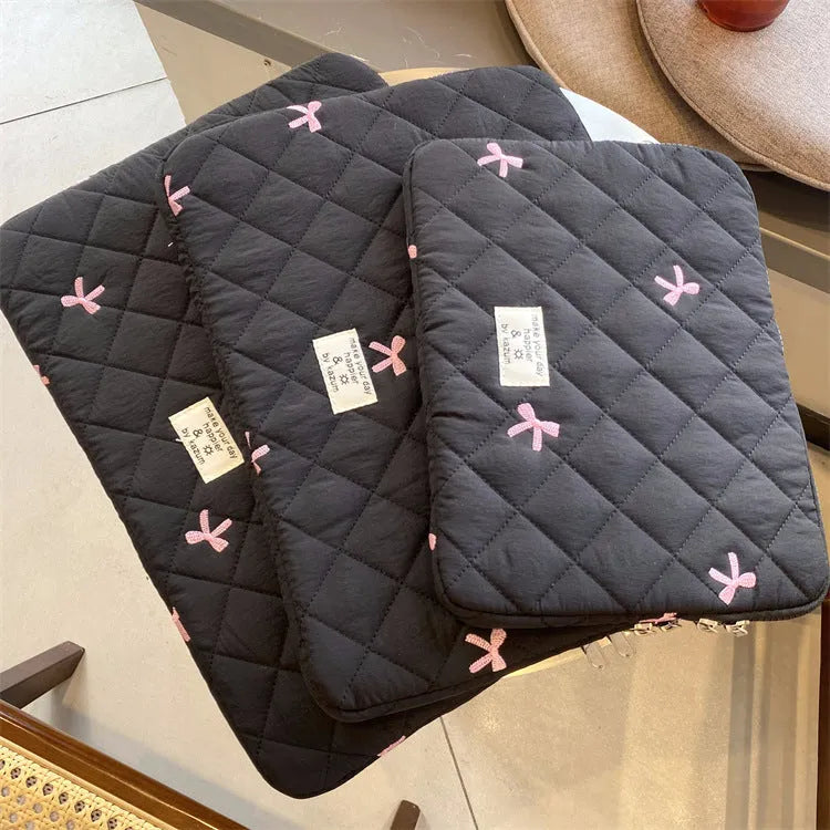 Nylon laptop storage bag with an embroidered rhombus bow in light pink colour.