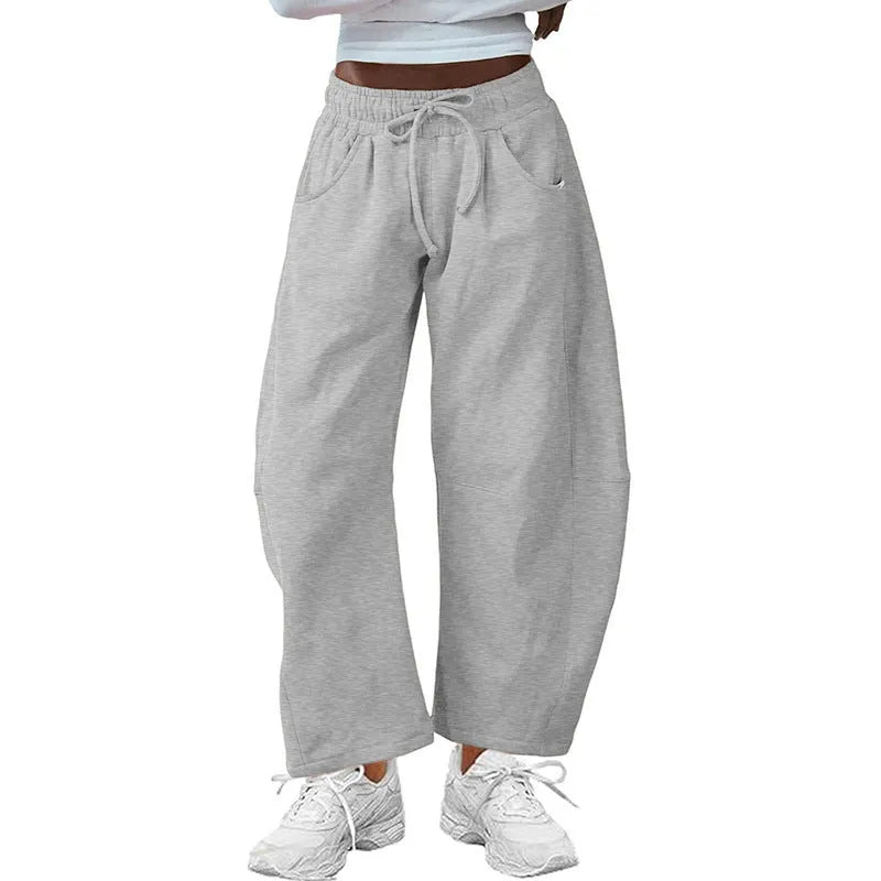 Loose grey cropped sweatpants with elastic drawstring waist and pockets on a mannequin