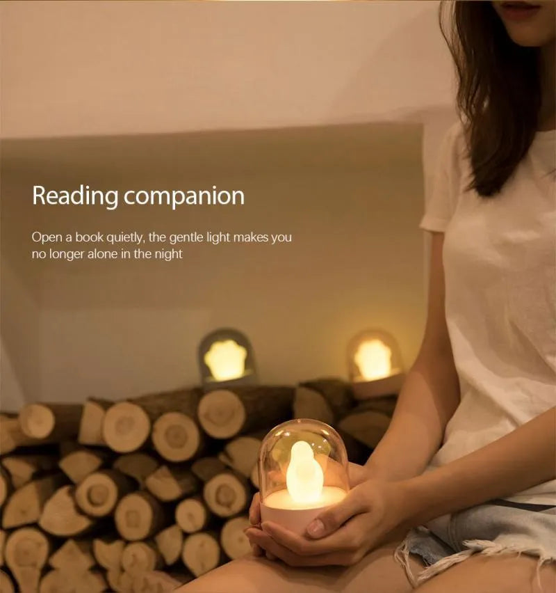 Grey cat paw USB night light with rotating illumination and music box function on wooden desk