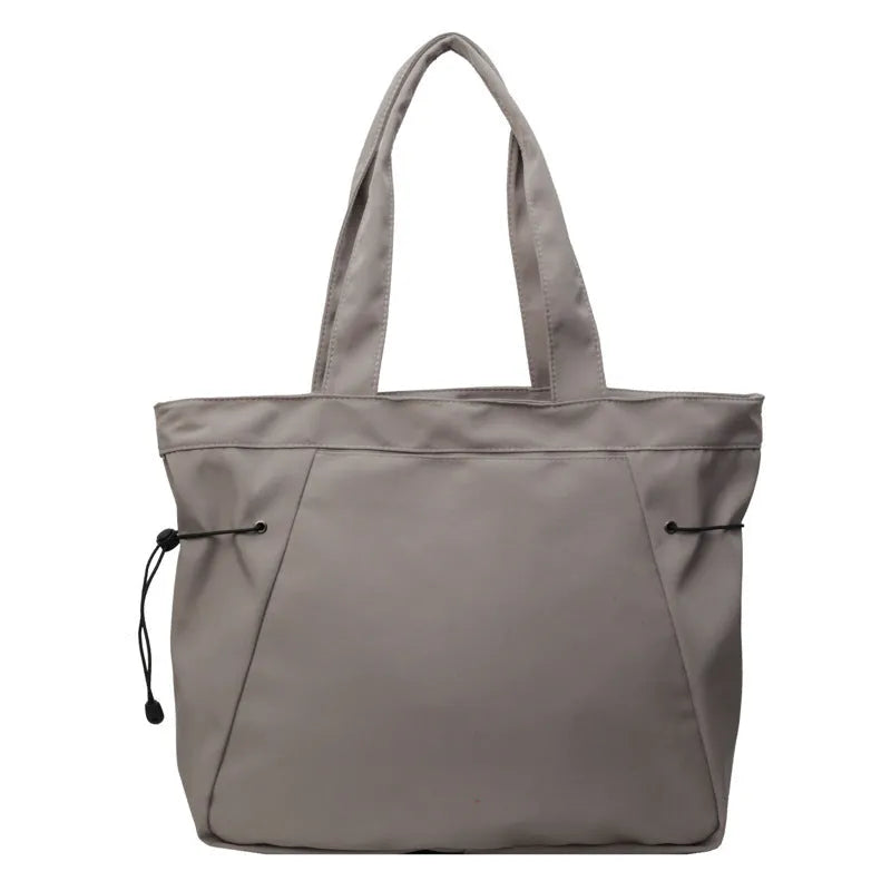 Soft folding shoulder tote bag in Oxford cloth shown in one of five colour options: black, brown, dark grey, light grey, or purple.