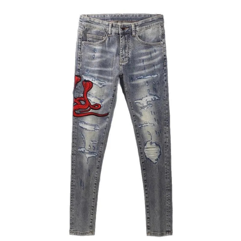 Worn looking washed-out slim fit jeans with hole patches and embroidered brand detail in old colour
