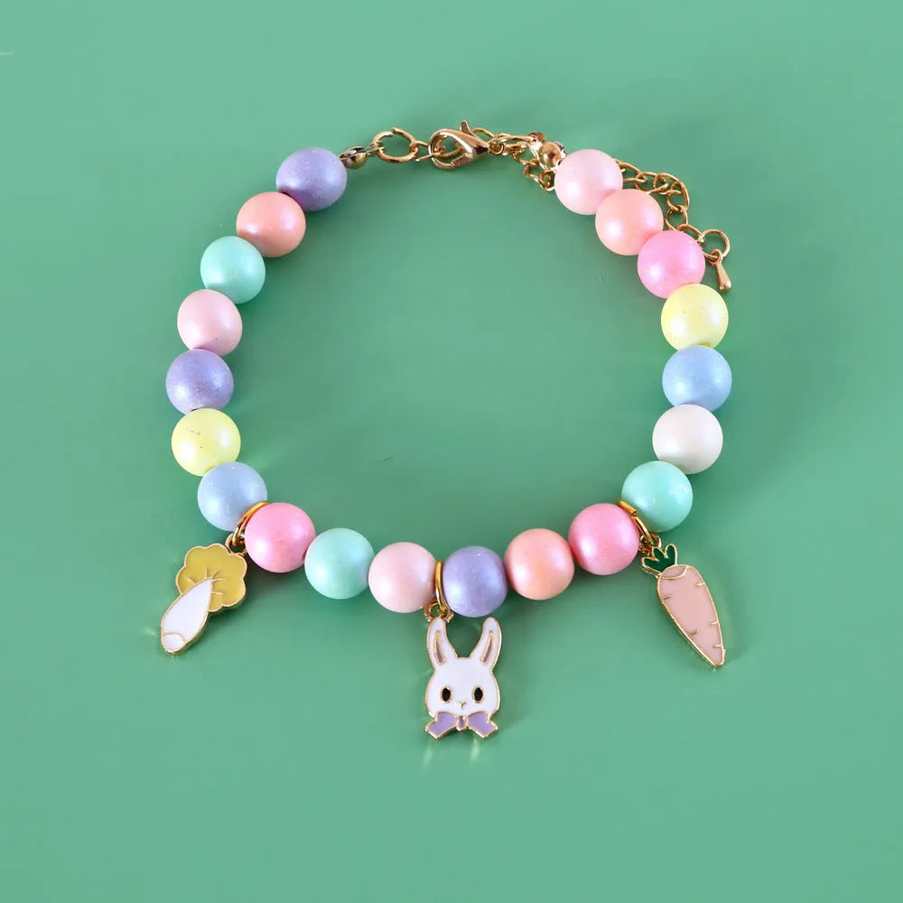 Colourful macaron charm pet collar and matching bracelet set in resin on a white background.