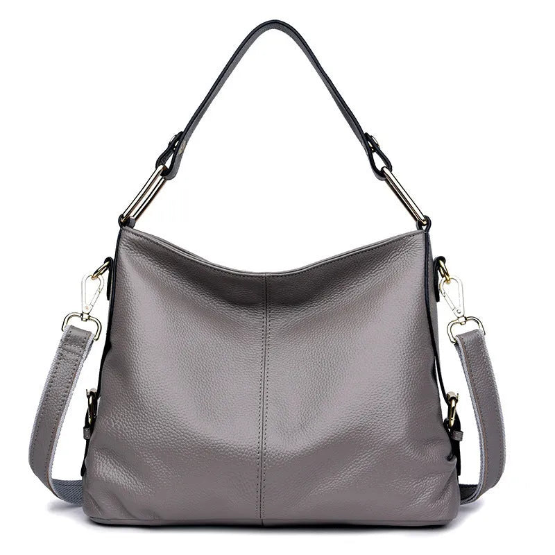 Genuine leather crossbody bag showing vertical square shape and internal compartments for phone and documents
