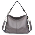 Genuine leather crossbody bag showing vertical square shape and internal compartments for phone and documents