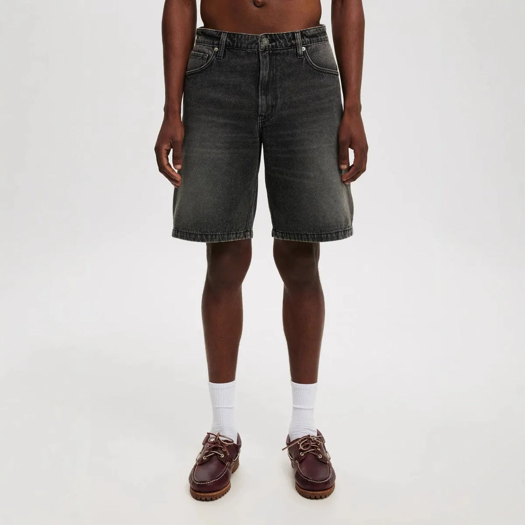 Man wearing loose fit light blue straight leg denim jeans, a streetwear summer style.