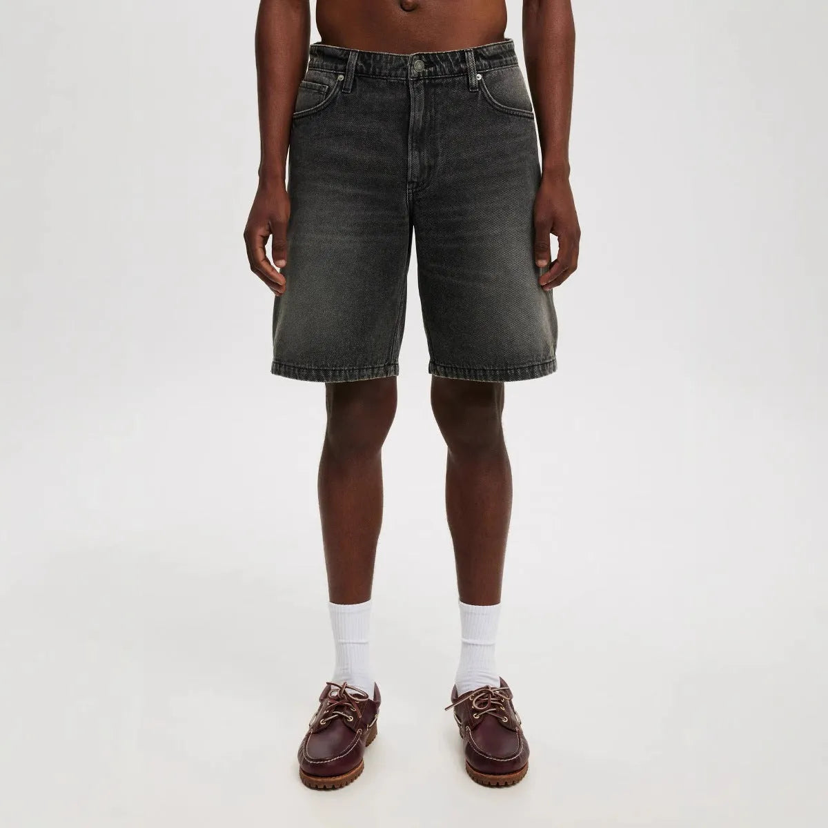 Man wearing loose fit light blue straight leg denim jeans, a streetwear summer style.