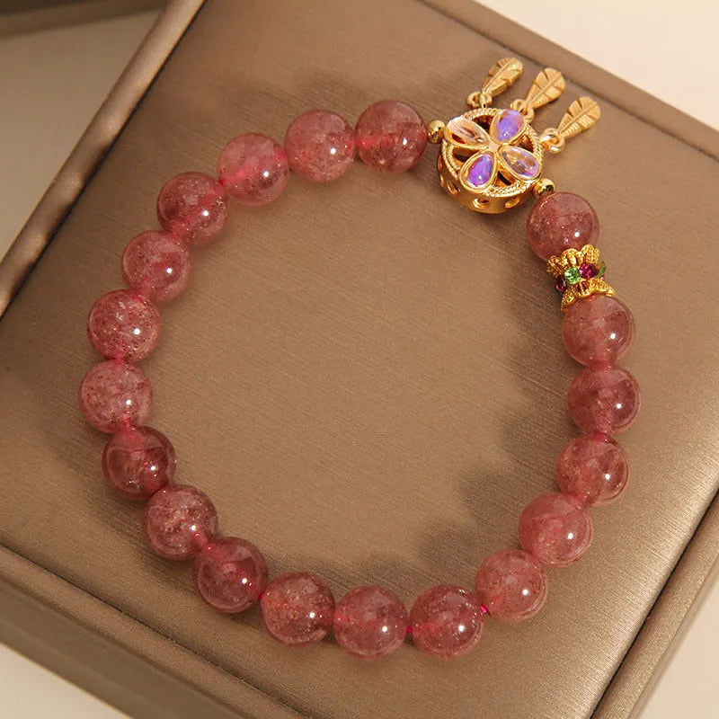 Women's strawberry quartz crystal bracelet with a four-leaf clover dream catcher ball pendant.