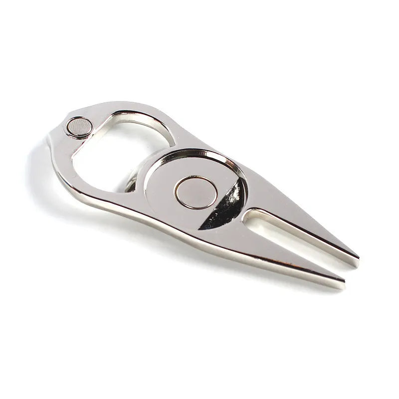 Black zinc alloy golf ball yoke fork with integrated bottle opener tool on green turf.