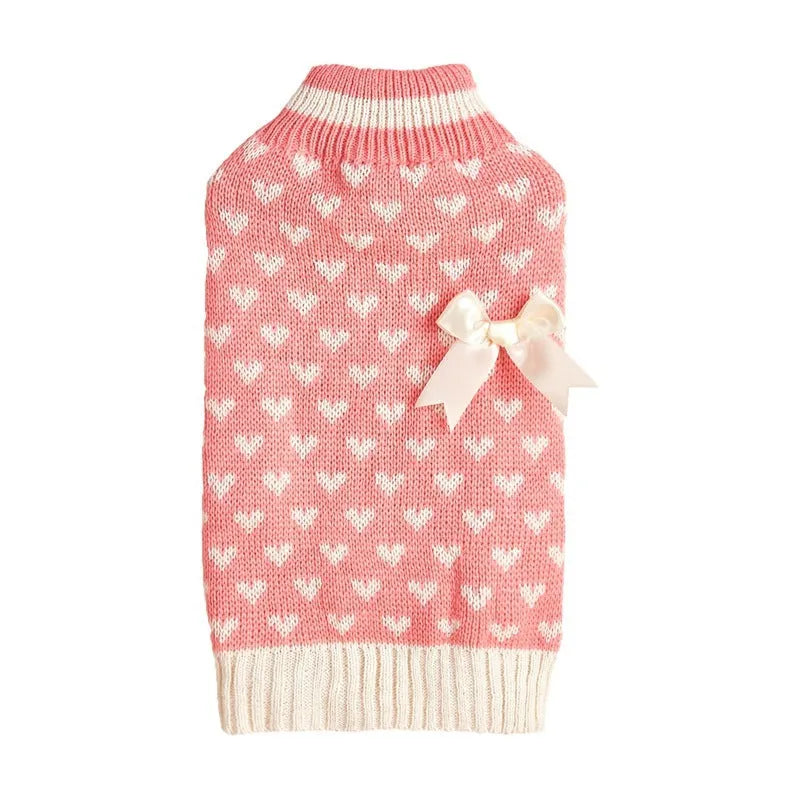 Small dog wearing a pink acrylic sweater with a bow and love heart design in ins style