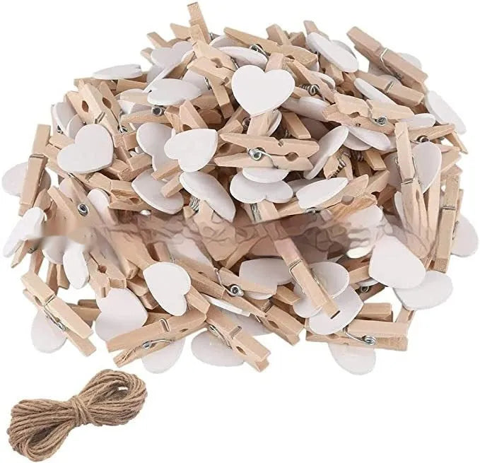 Five handmade solid wood heart-shaped clips in red, white, and pink on a wooden surface.