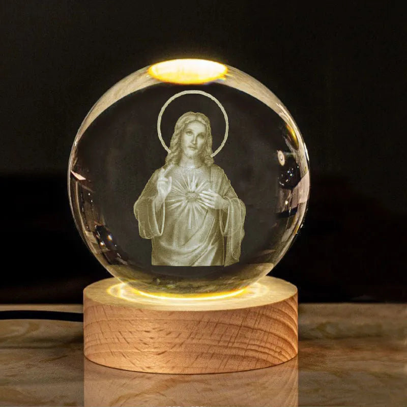 White crystal ball ornament on wood base with warm light and religious symbols