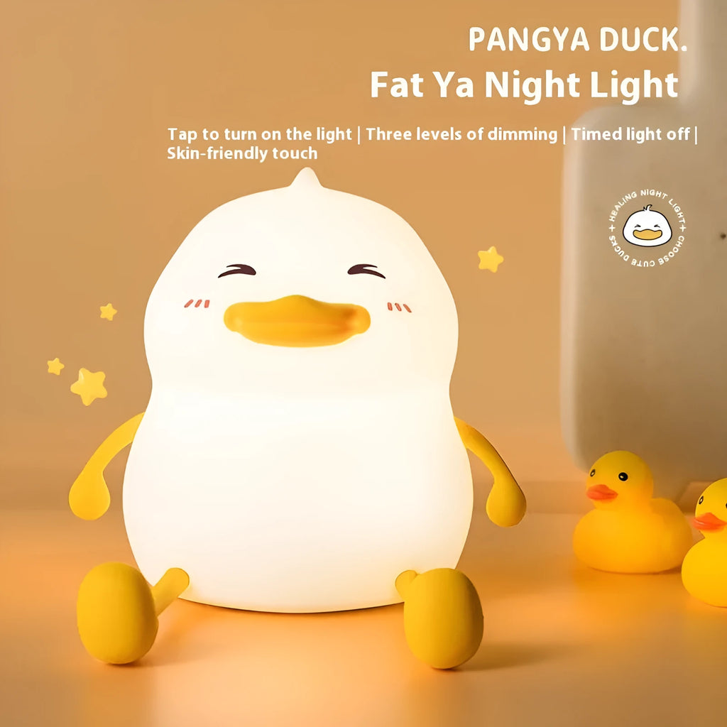 Chubby white silicone rechargeable night light on a wooden desk surface.