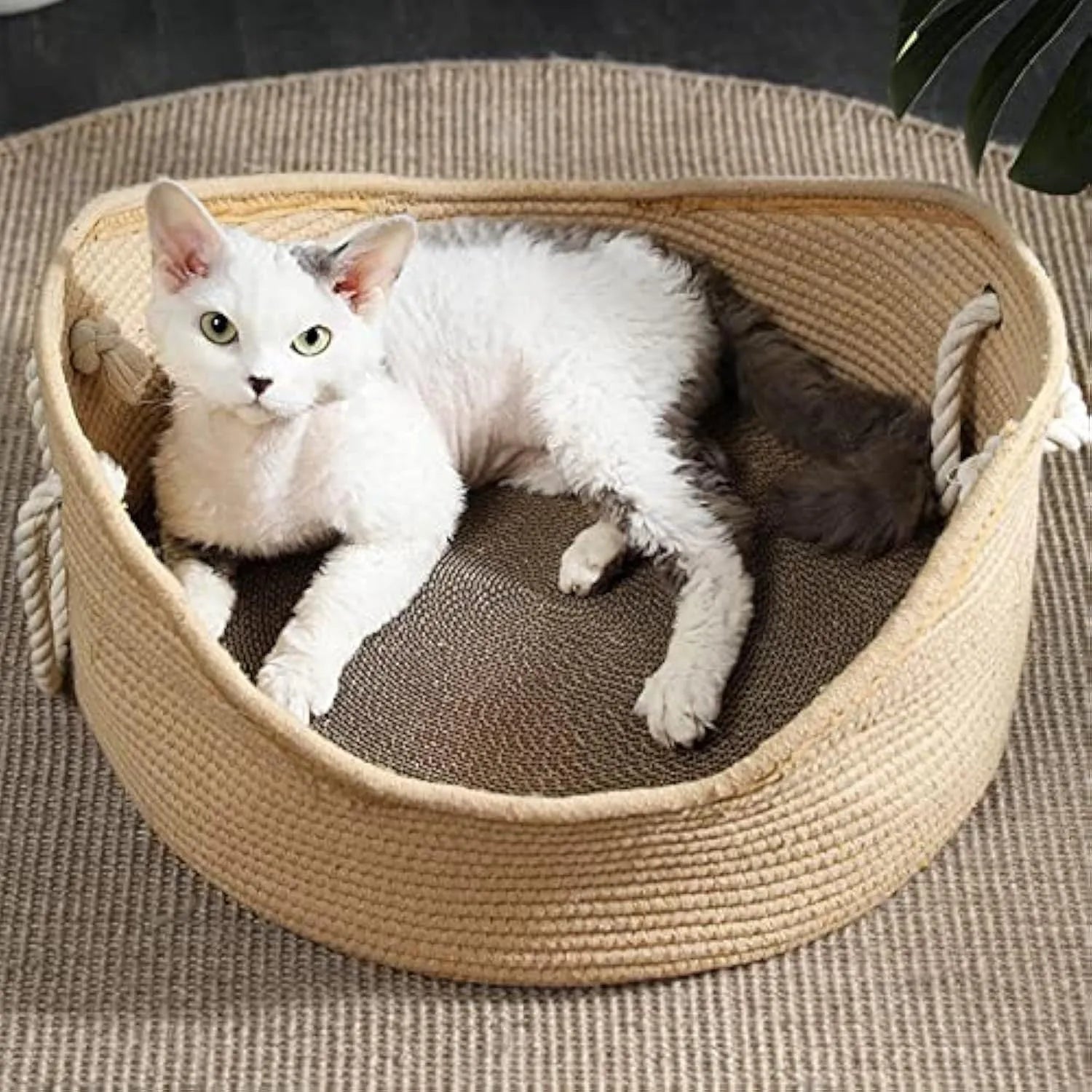 A square wicker cat bed basket with an integrated corrugated cardboard scratching panel on one side.
