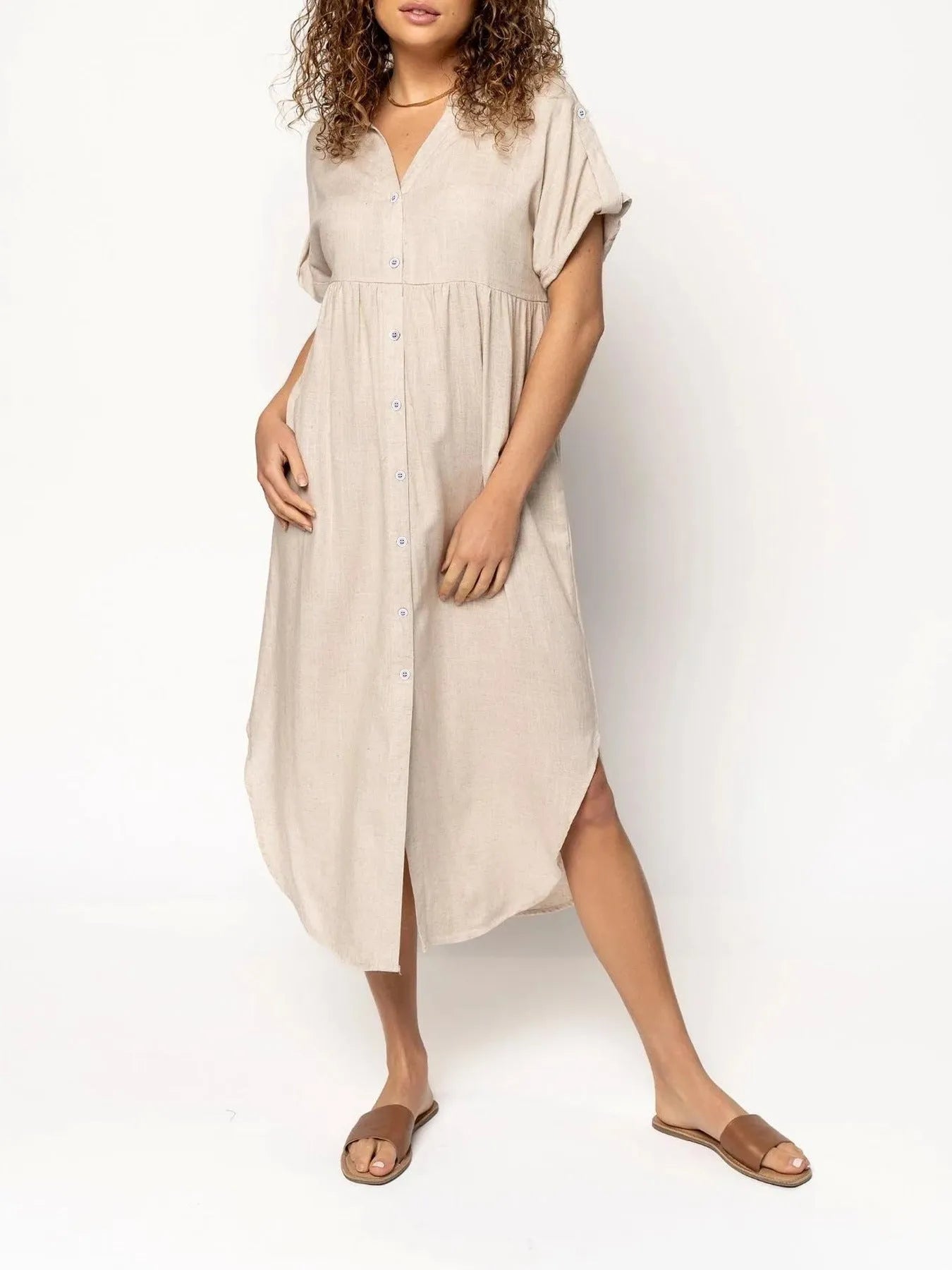 A loose-fitting, mid-length casual dress with button detail on the front, shown in a solid colour.