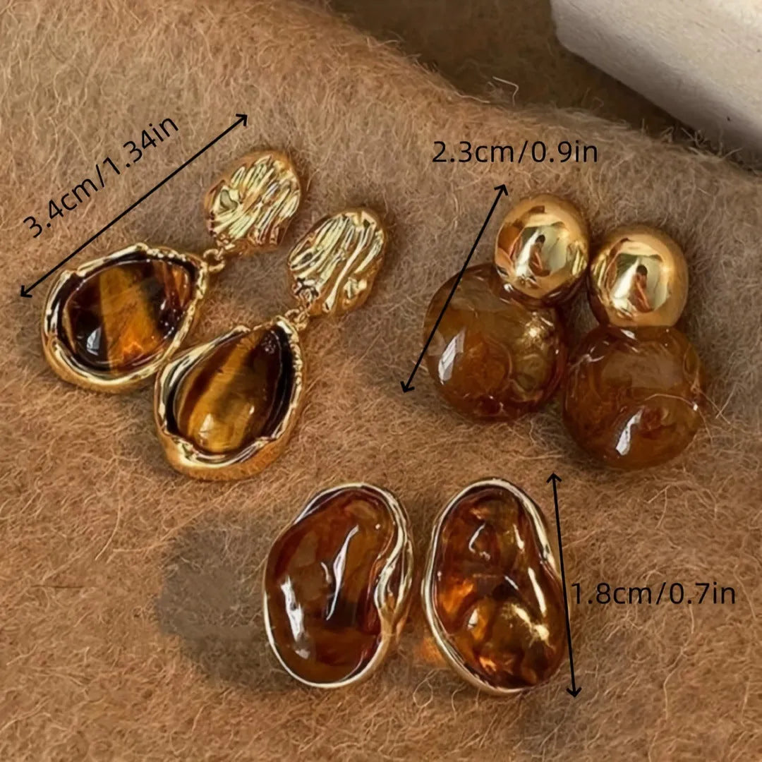 Three pairs of handmade geometric ear studs with electroplated alloy construction and tassel detailing in different colour treatments