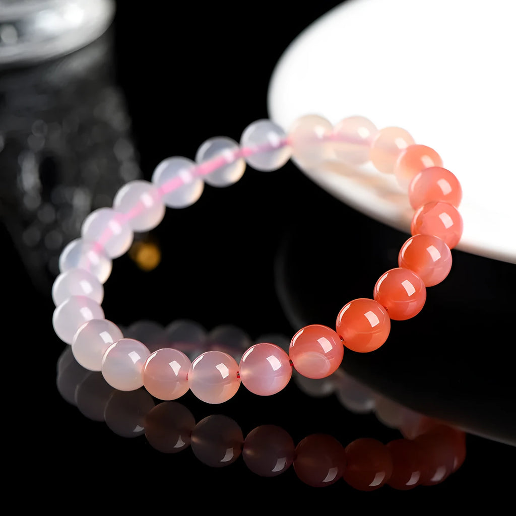 Natural gradient Yanyuan agate bracelet with spherical beads on a white background.