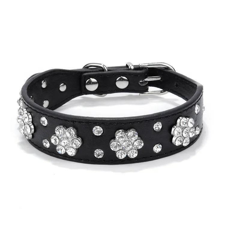 PU leather dog collar with rhinestone flower studs in black, showing metal D-ring and adjustable eyelets.