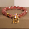 Women's strawberry quartz crystal bracelet with a four-leaf clover dream catcher ball pendant.