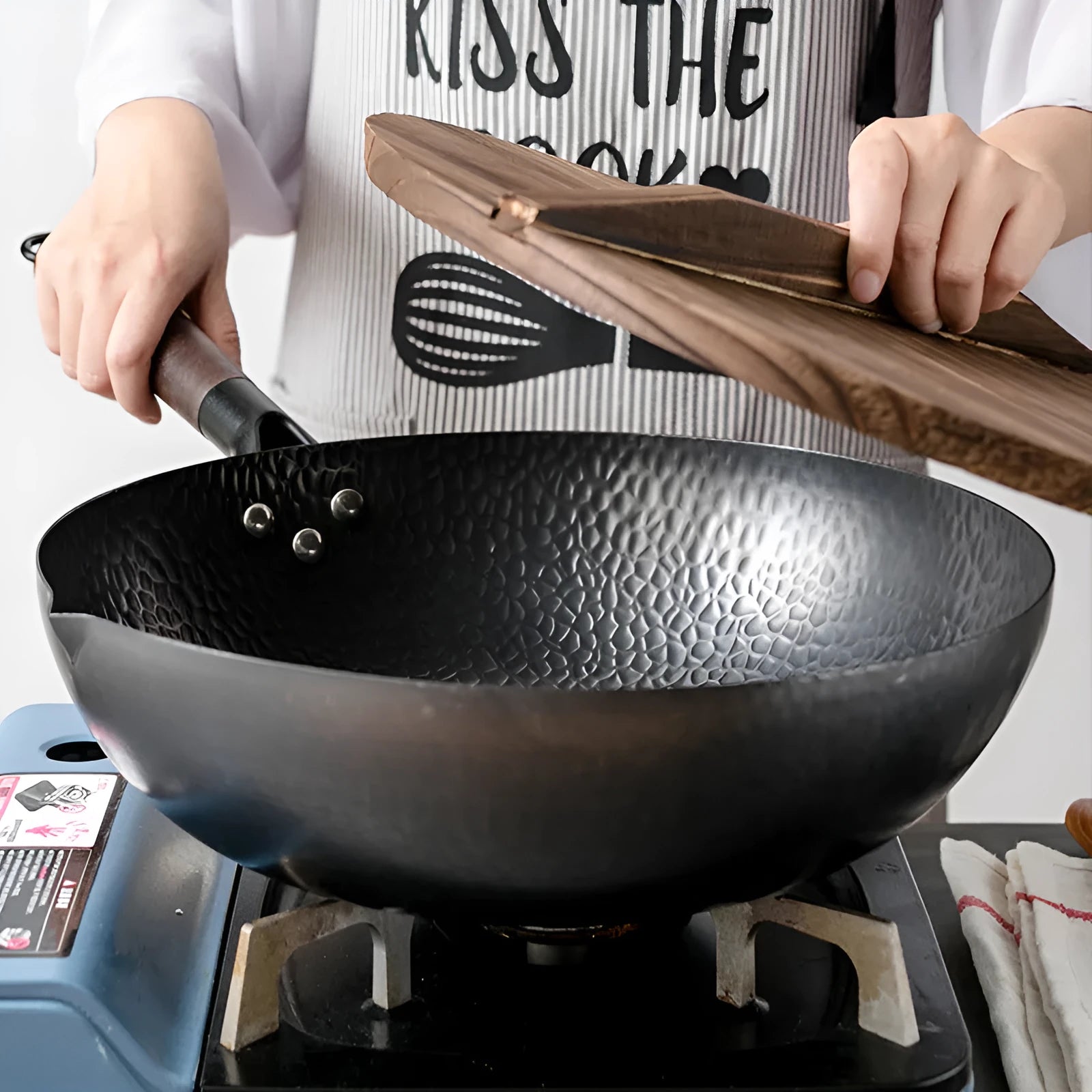 Traditional handmade iron wok pan with wooden handle and induction-compatible base