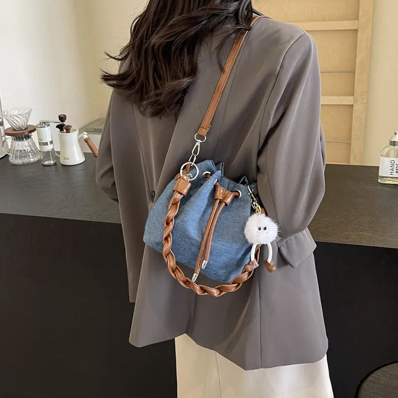 Blue synthetic leather cross-body bucket bag with adjustable strap and sandwich pocket