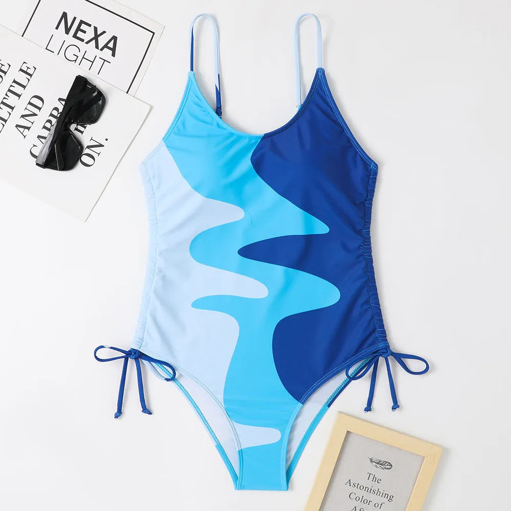 Blue women's sleeveless backless one-piece swimsuit with a striped print, made from polyester and nylon fabric.