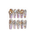 Ten false nail patches with rhinestones on a card, next to jelly adhesive and manicure tools.