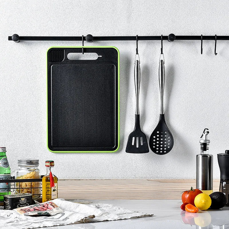 Grey square double-sided aluminium cutting board with hanging loop, defrosting surface, and built-in whetstone