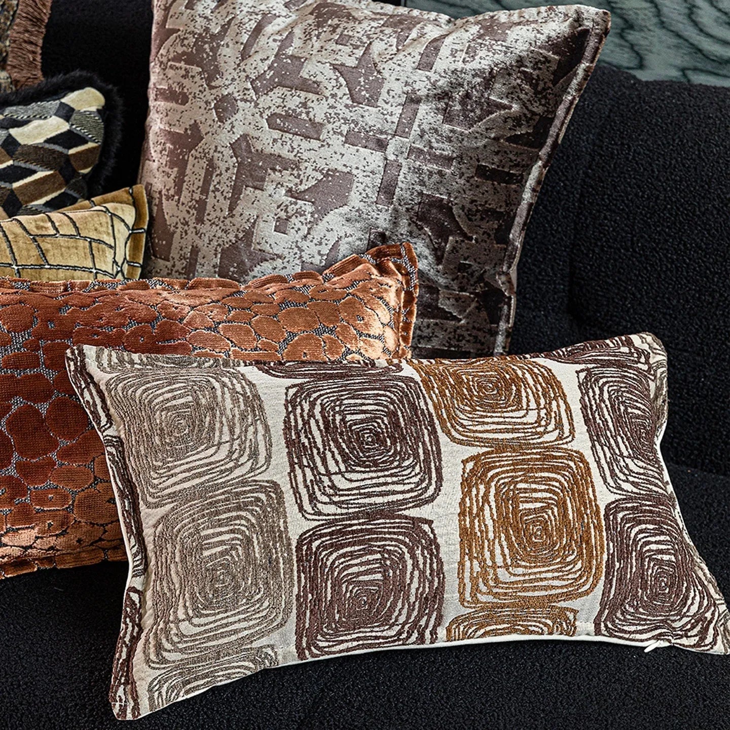 Cream and coffee abstract coil pattern pillow cover on a grey sofa