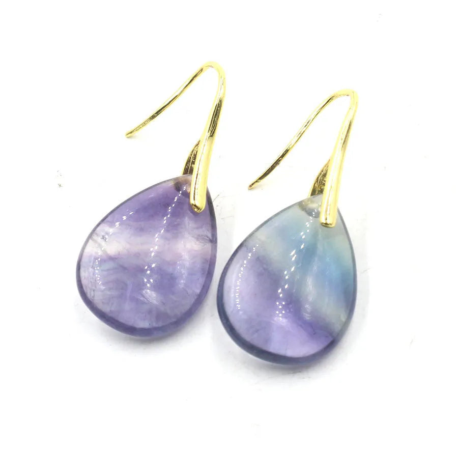 A pair of geometric water drop earrings made from crystal, shown in one of nine available colours like amethyst or obsidian.