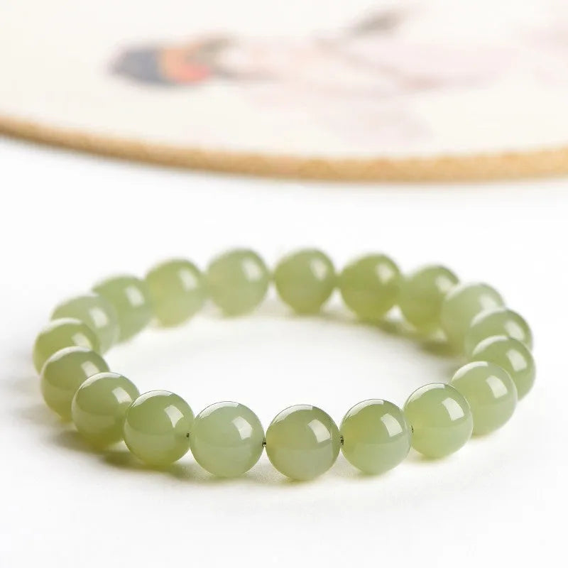 Polished Hetian jade bead bracelet in clear ice-like colours on a white background.