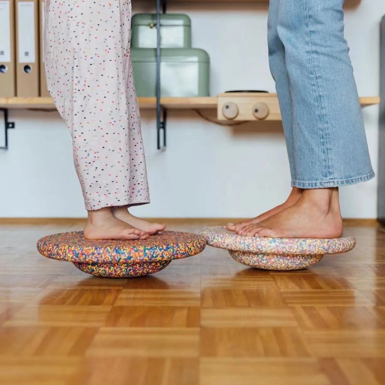 Plastic surfboard-shaped balance board for children, shown in mixed wood colour and black options.