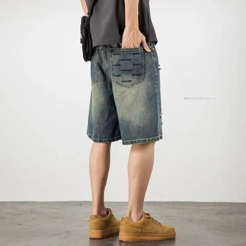 Blue retro-style men's denim shorts with a loose fit, distressed holes, and a straight-leg cut.