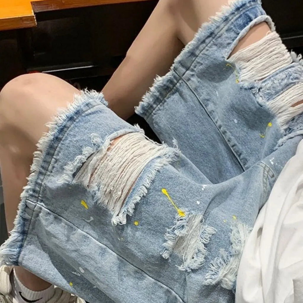Men's loose fit light blue denim shorts with a water washed finish and hole detailing on a solid background.