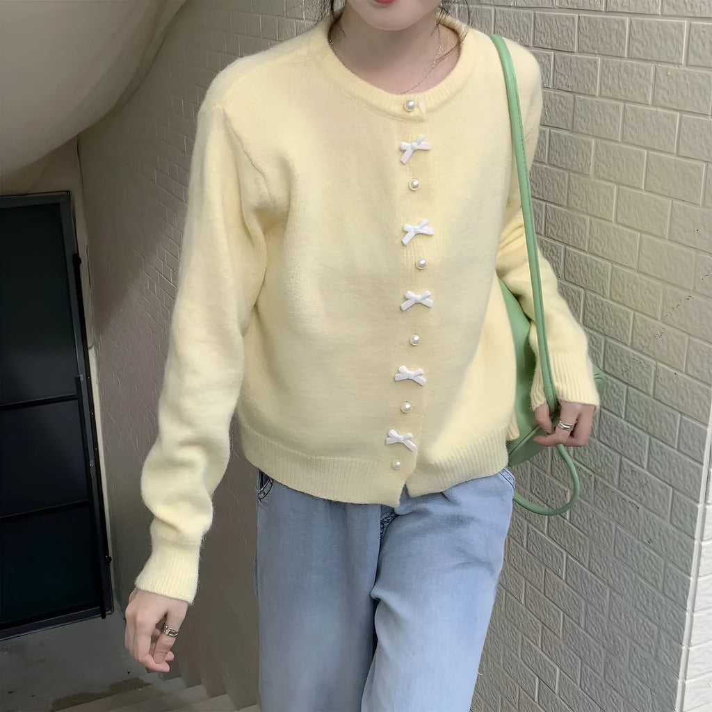 Women's solid colour cardigan sweater with bow and pearl button design in medium thickness fabric