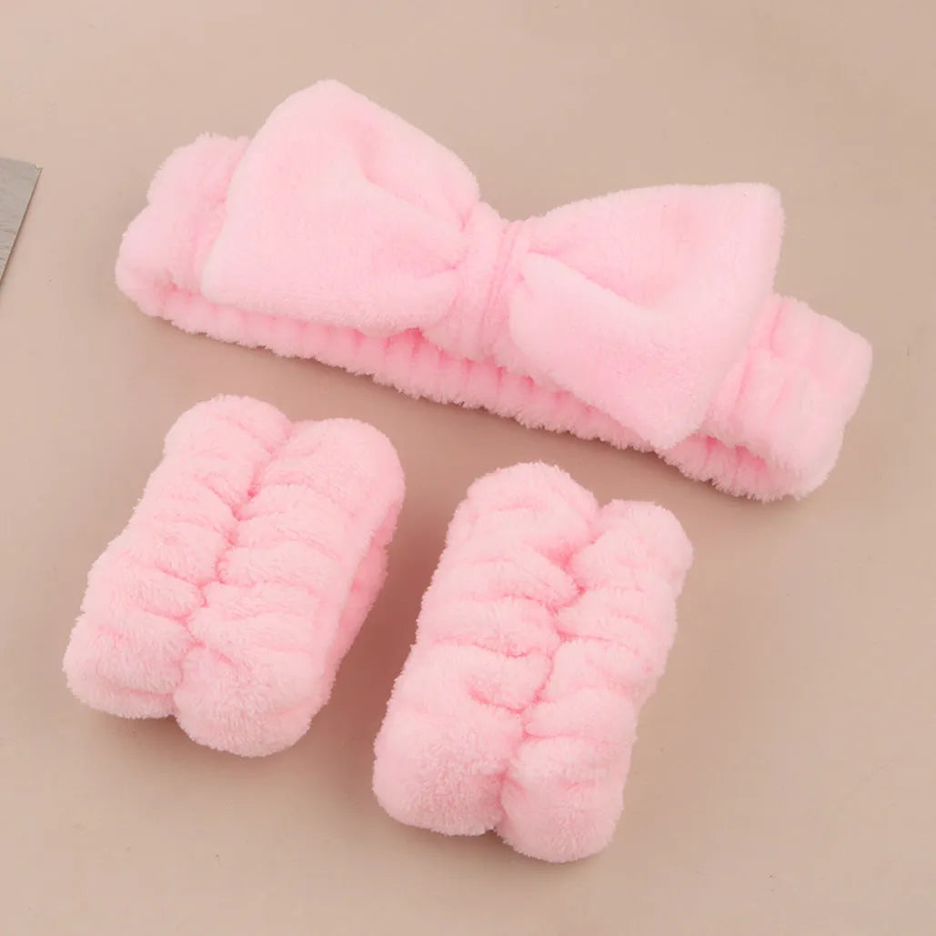 Facial brush with plastic handle and nylon bristles alongside coral fleece absorbent hair band in purple colour
