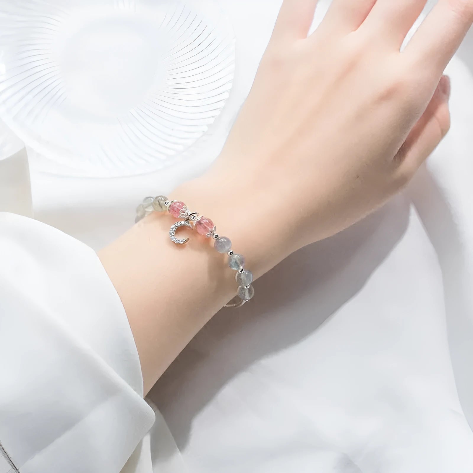 Handmade adjustable bracelet with a natural moonstone and silver crescent moon charm on a wrist.