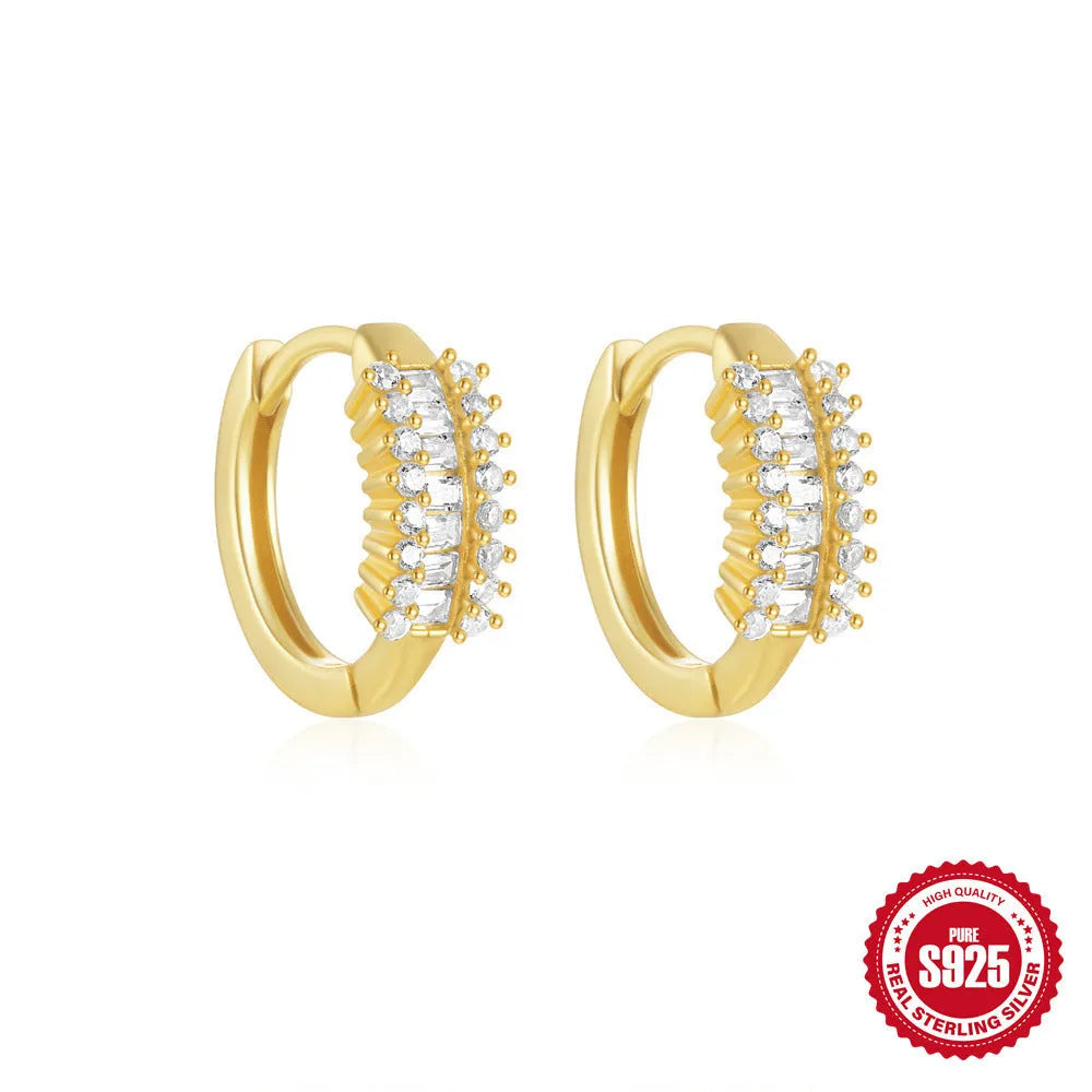 A pair of small, round, geometric stud earrings made of sterling silver with an electroplated finish.