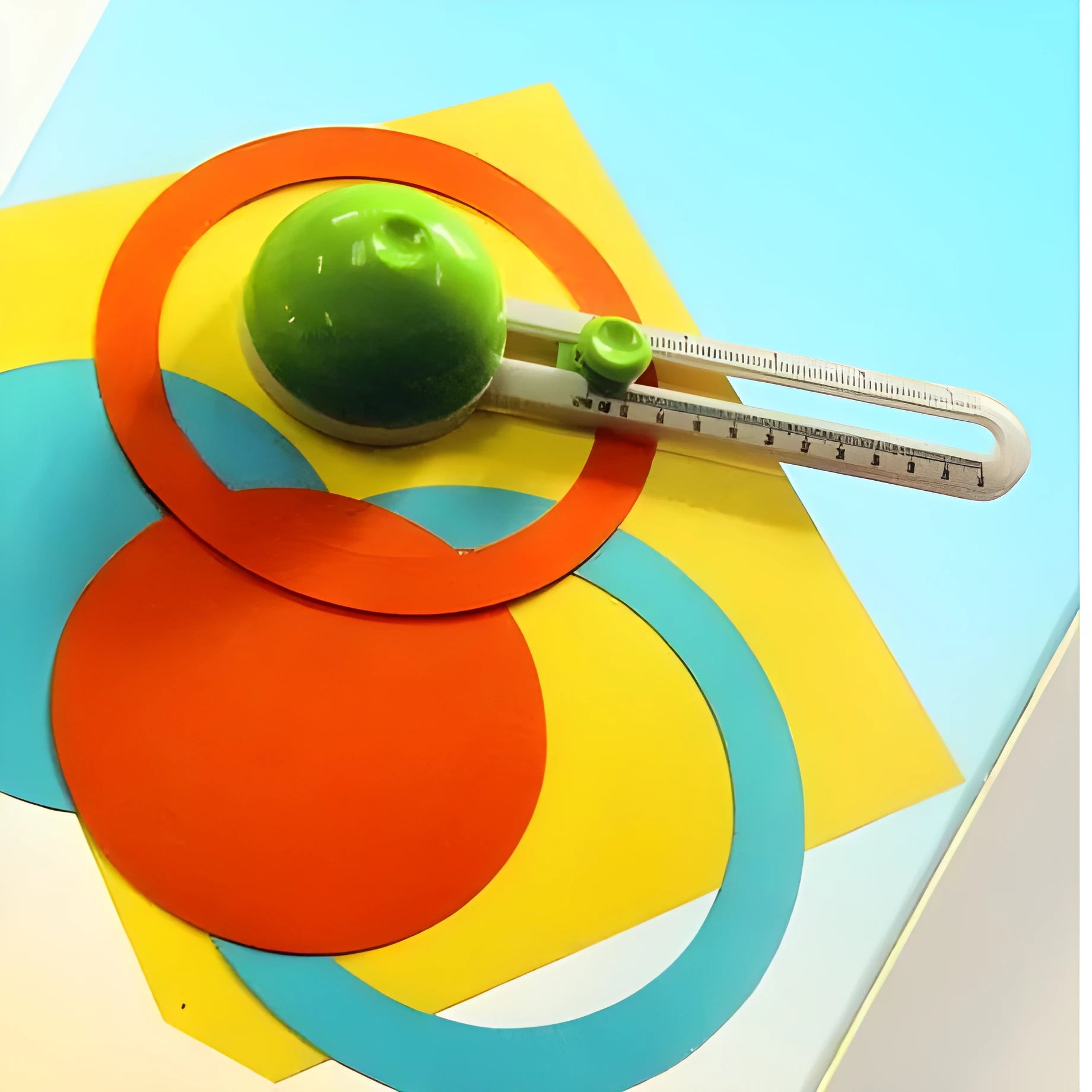 Orange plastic round paper cutter for A3 sheets on a colour box