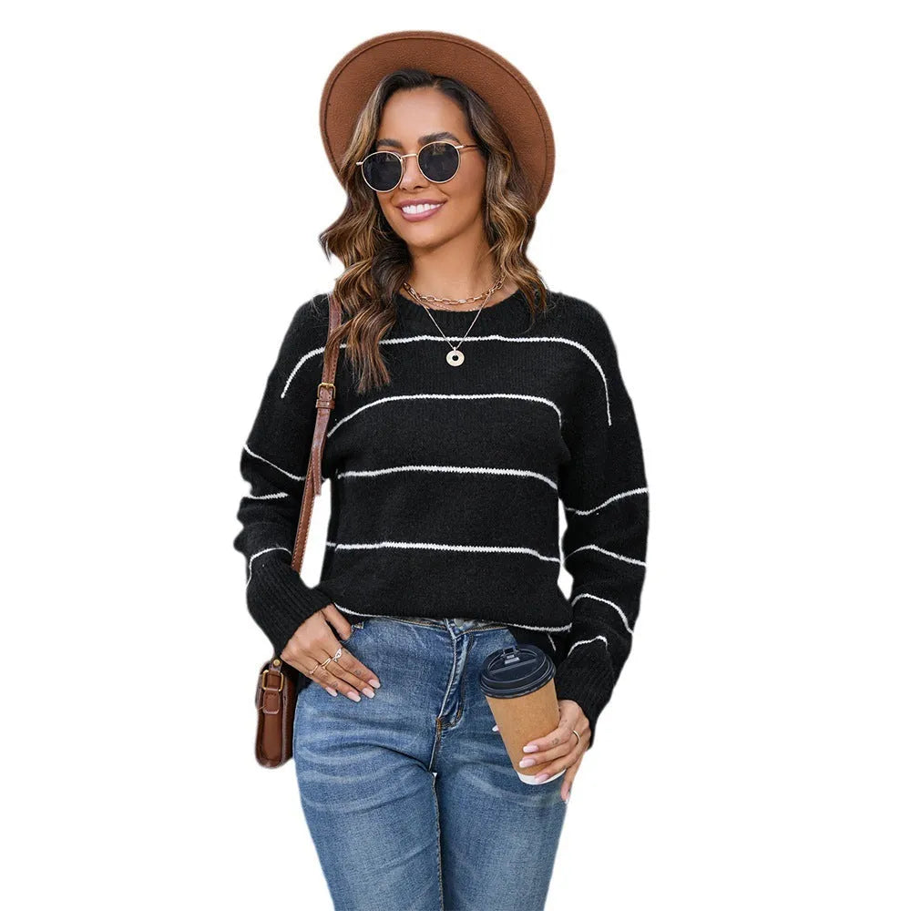 Women's black and white striped loose-fit pullover sweater with round neck and regular sleeves.