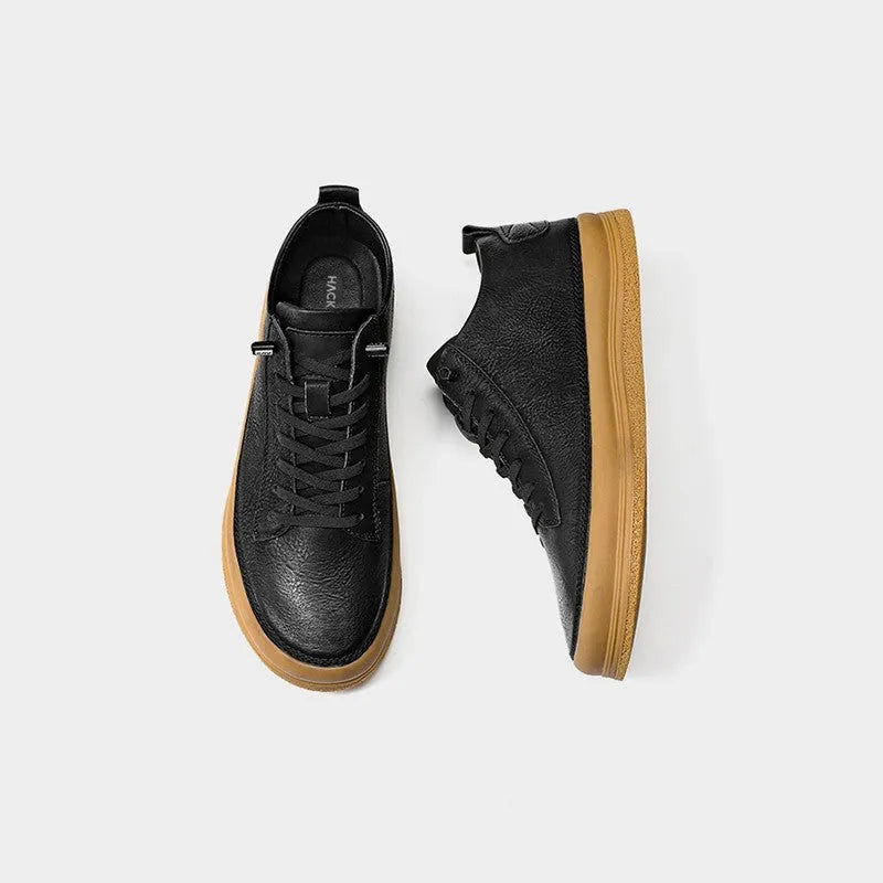 Men's black casual leather shoes with a round toe and white rubber sole on a plain background.