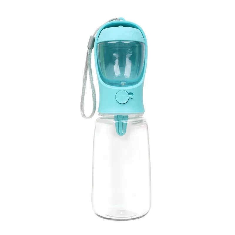A blue portable plastic dog water bottle with an integrated flip-out drinking bowl on a green background.