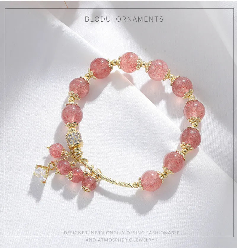Pink women's bracelet with heart-shaped strawberry quartz crystal beads and freshwater pearl accents on a wrist.